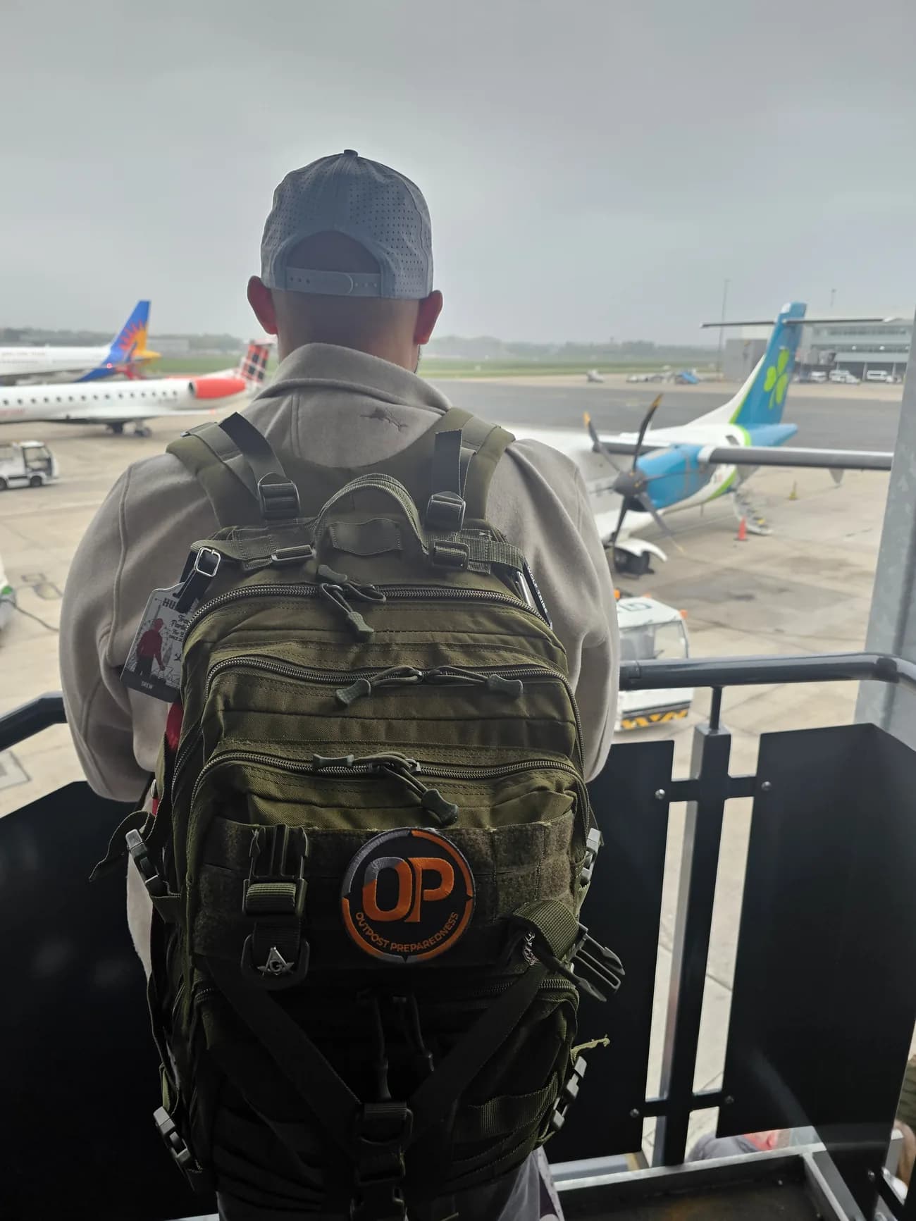 An Outpost go-bag worn at an airport gate with an aircraft on stand behind