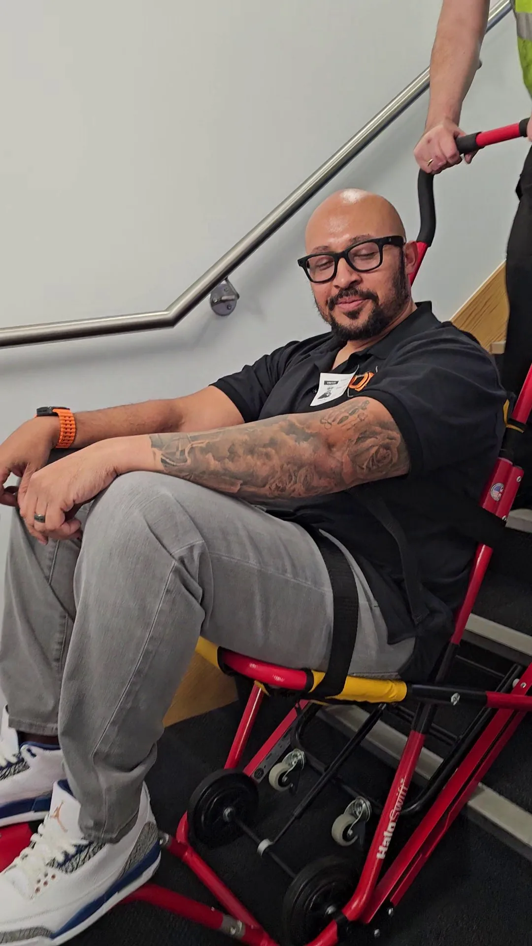 A HALO evacuation chair being lowered down a stairwell by one operator