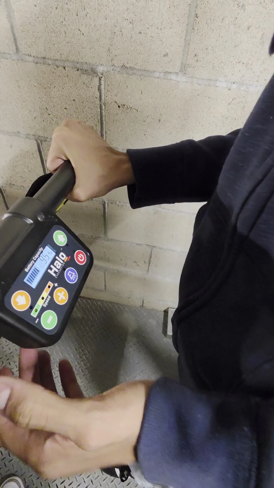 A hand operating the illuminated controller of a HALO Power evacuation chair
