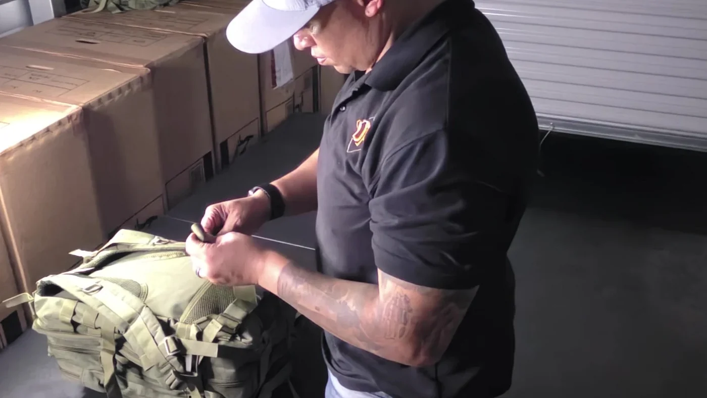 Drew Jennings packing an Outpost go-bag by hand at the warehouse bench