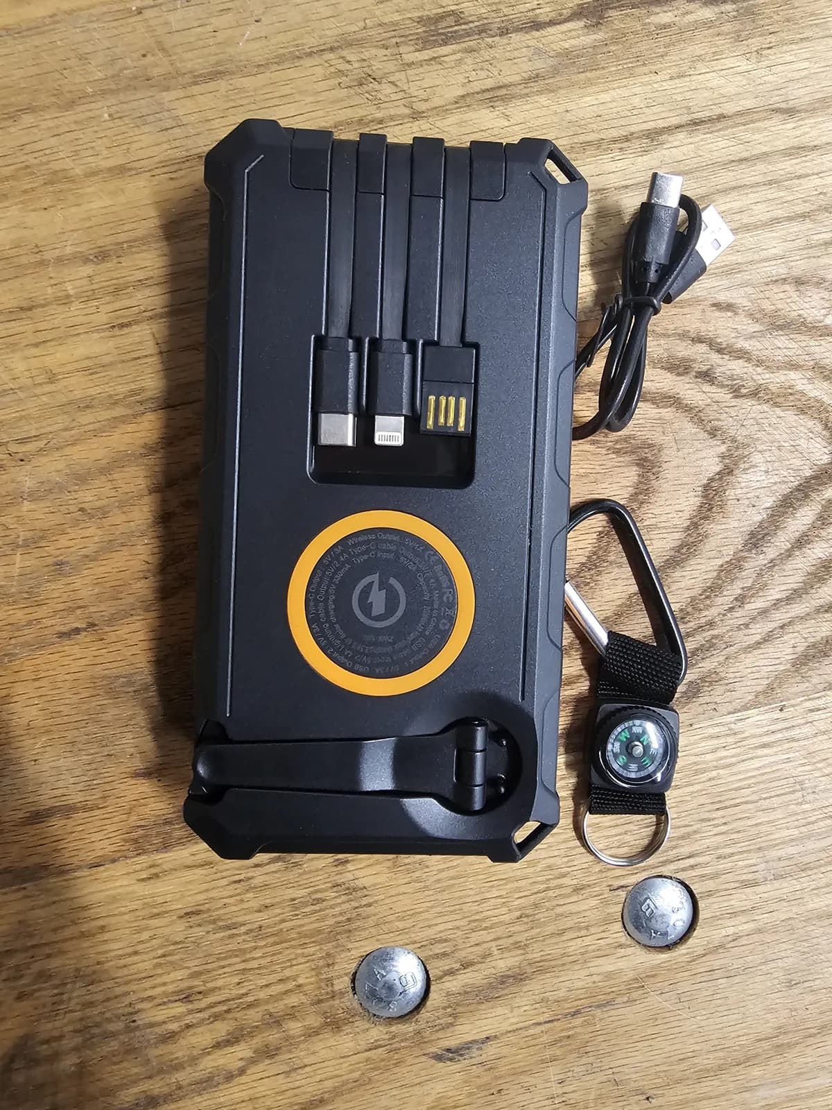 The ports face of the 20,000 mAh power bank, showing built-in cables and the wireless charging pad