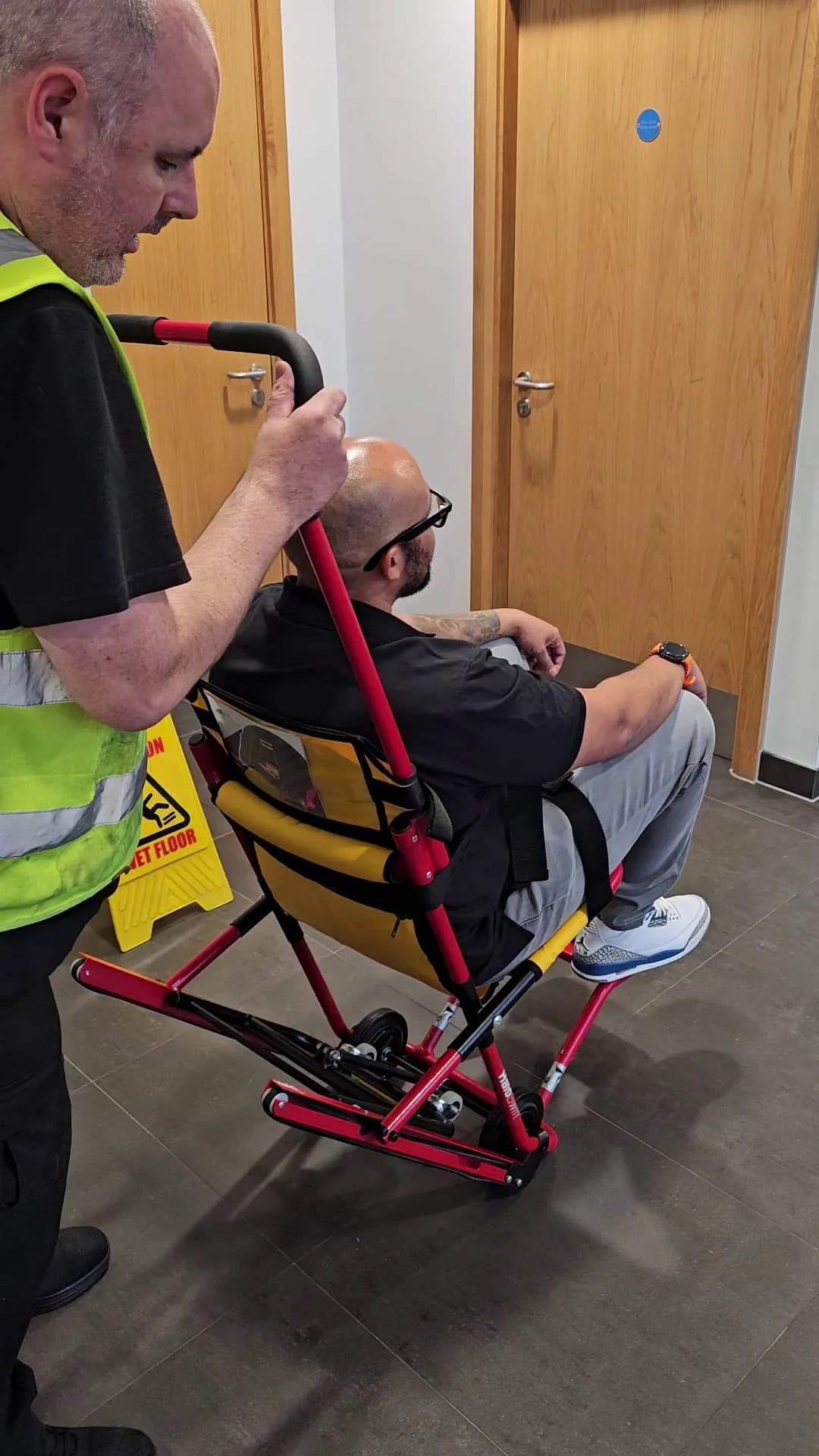 A HALO evacuation chair being manoeuvred through a corridor