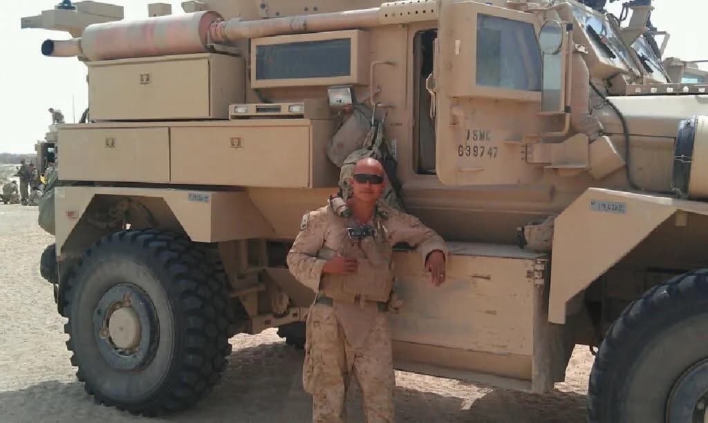 Staff Sergeant Jennings beside an armoured vehicle in Helmand Province, Afghanistan